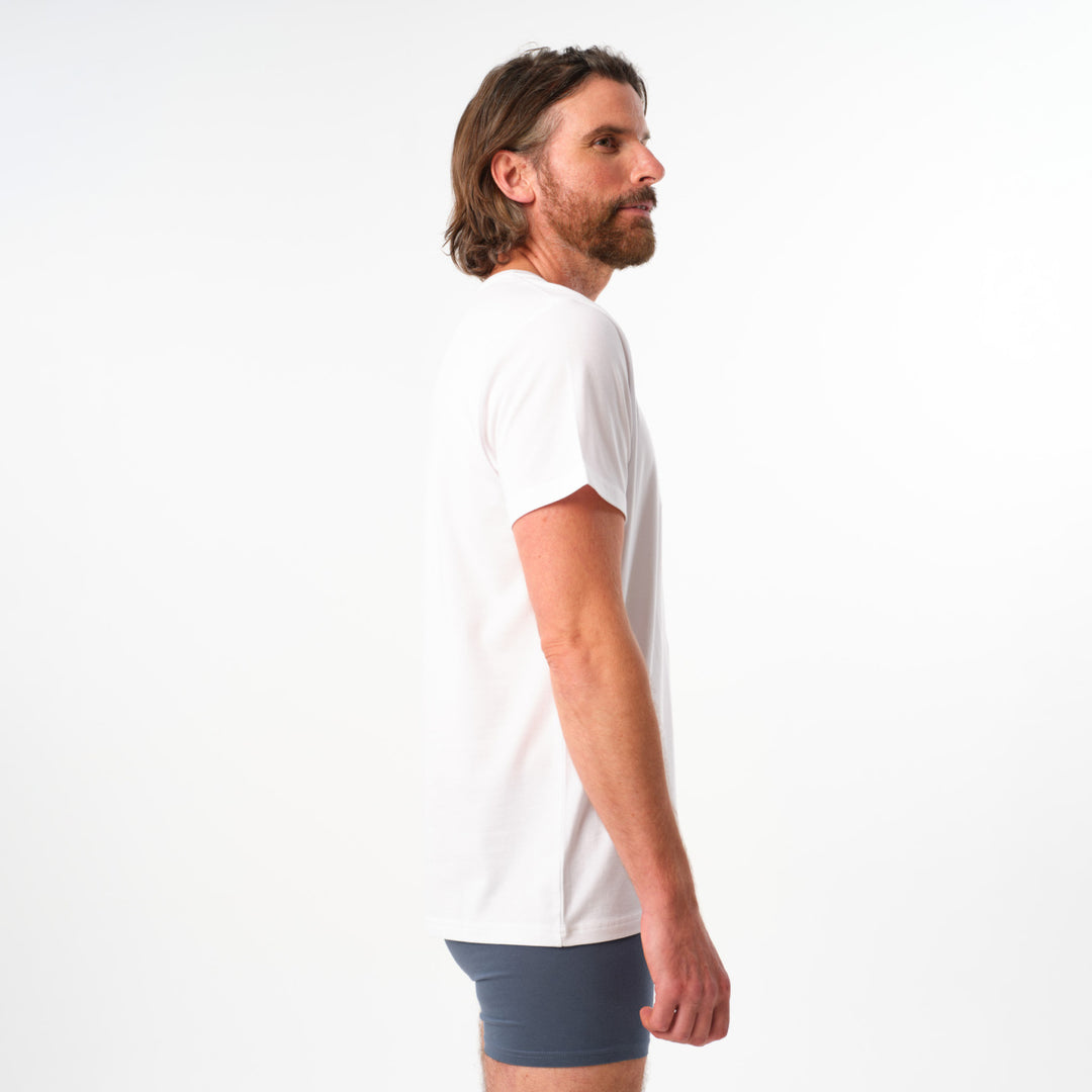 Man wearing a white t-shirt and blue shorts on a white background