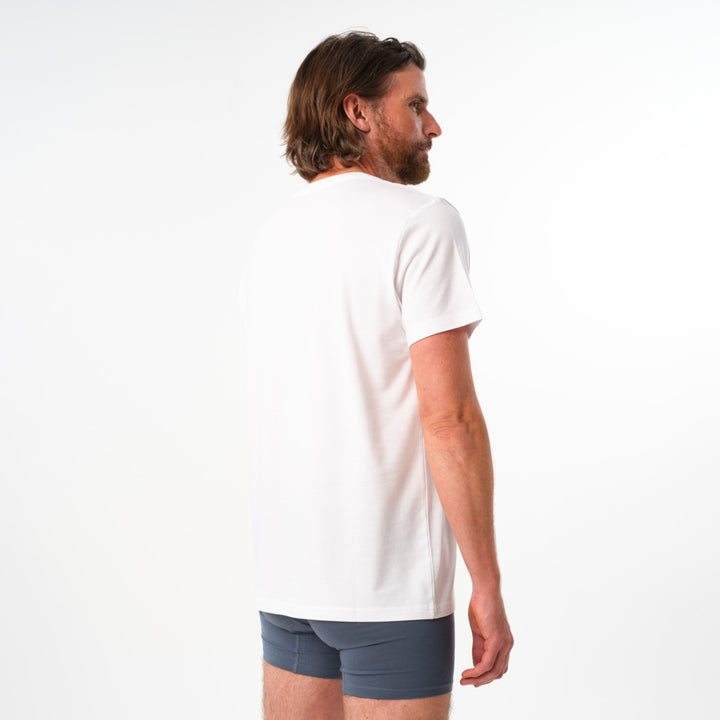 Man wearing a white t-shirt and gray boxer briefs on a white background